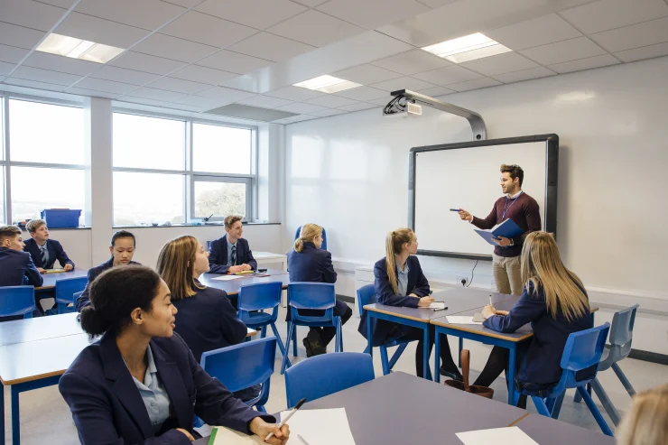 09c6975aa7a83c04b60bb4cdaa8e76fdf1ca84a0 A teacher exemplifying one of the 10 essential classroom management skills as her class is focused and organised.