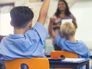 8553cd8f72c34069a3bc3fd4f24acba1 A teacher exemplifying one of the 10 essential classroom management skills as her class is focused and organised.