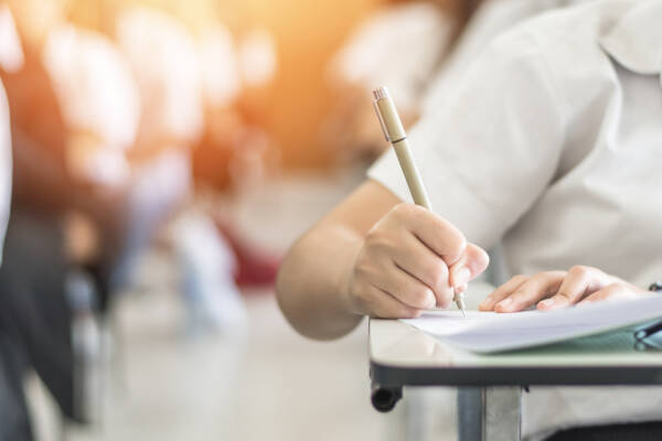 Exam with school student having a educational test, thinking hard, writing answer in classroom for university education admission and world literacy day concept A teacher exemplifying one of the 10 essential classroom management skills as her class is focused and organised.