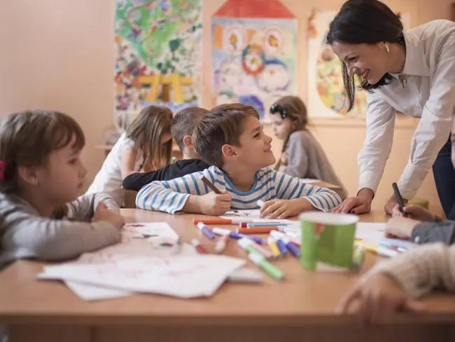 children learning A teacher exemplifying one of the 10 essential classroom management skills as her class is focused and organised.