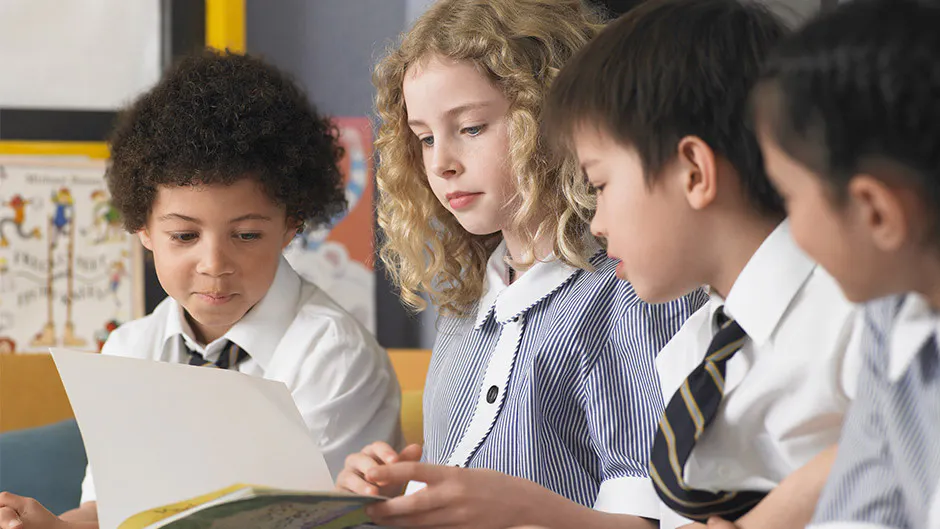 kidsreading A teacher exemplifying one of the 10 essential classroom management skills as her class is focused and organised.