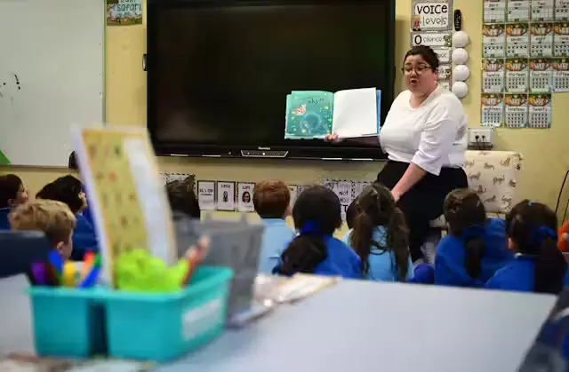 reading A teacher exemplifying one of the 10 essential classroom management skills as her class is focused and organised.
