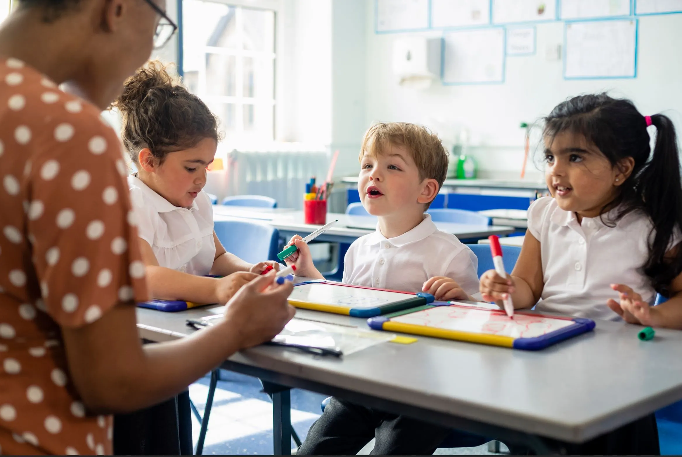 reading_children A teacher exemplifying one of the 10 essential classroom management skills as her class is focused and organised.