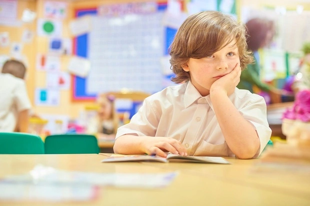child reading A teacher exemplifying one of the 10 essential classroom management skills as her class is focused and organised.